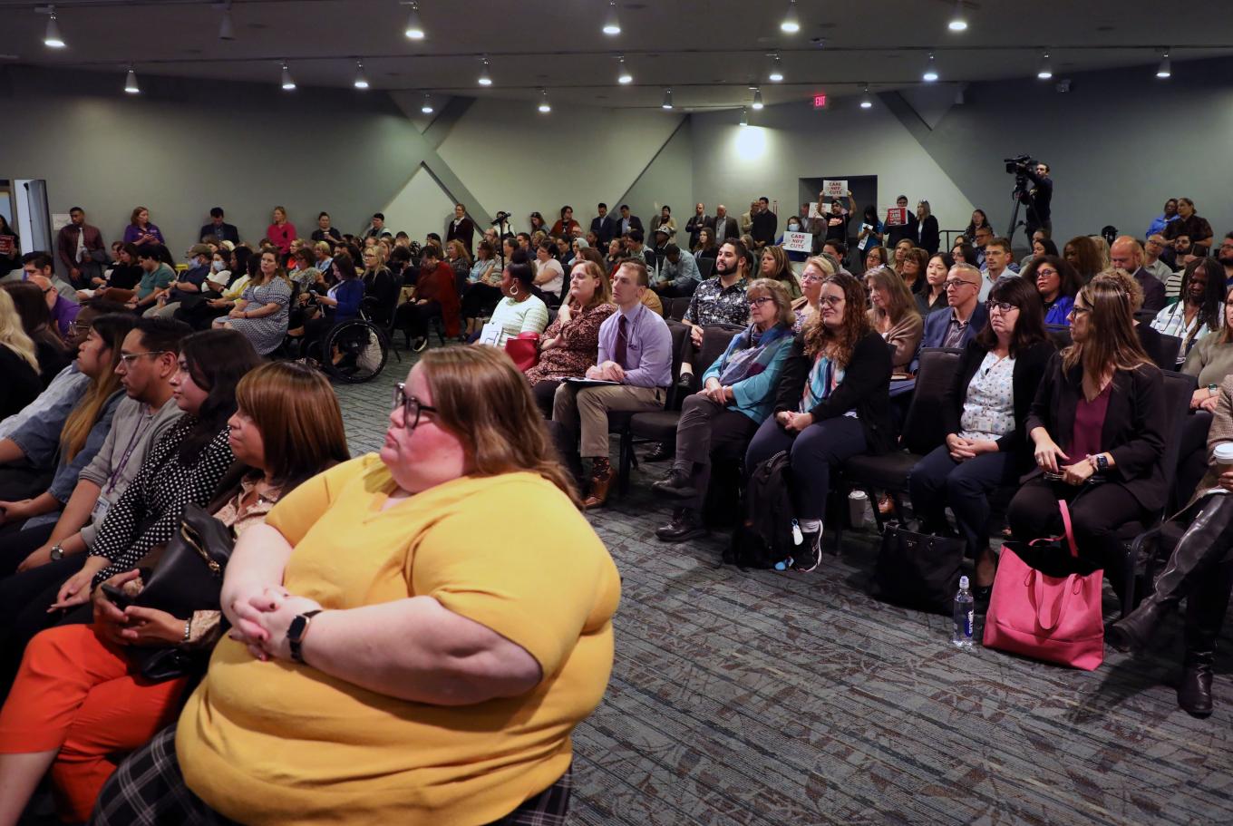 Dozens of participants at the DREAM opening ceremony are seated in rows and listening attentively.