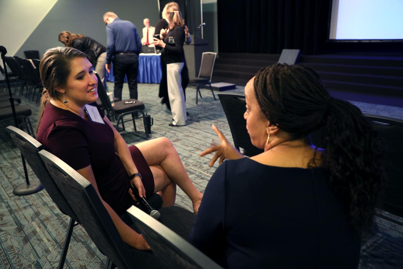 Kaitlyn Jackson, policy associate at the Yang-Tan Institute (left), listens intently to Charyl Yarbrough who is waving a hand for emphasis while speaking. 