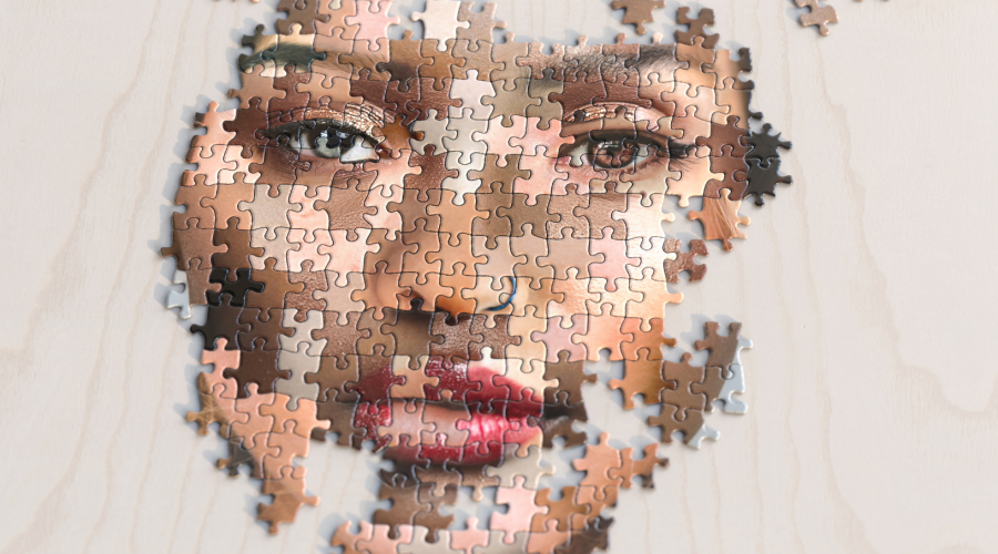 Different color puzzle pieces making up a face.