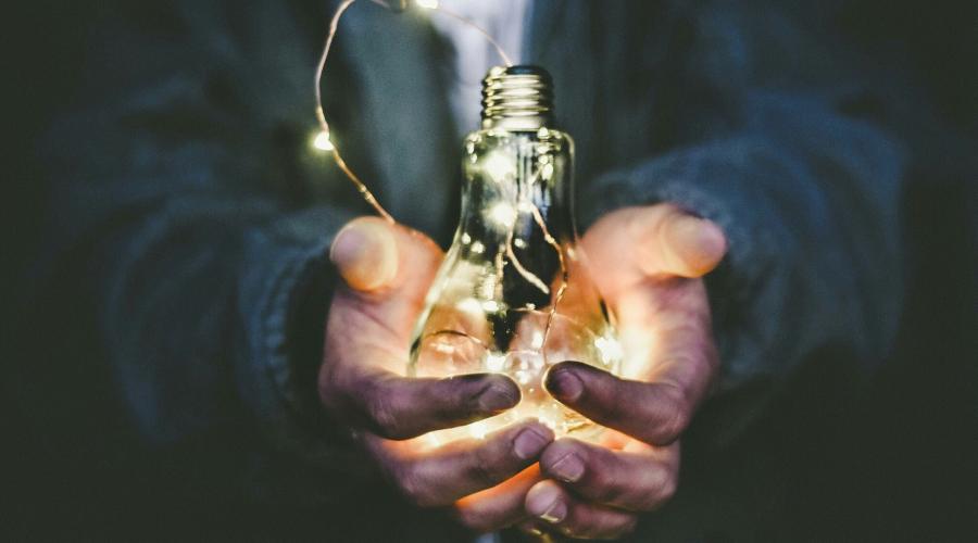 hands holding a lightbulb