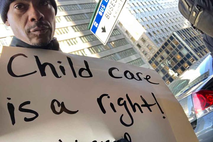 Steve Peraza holding a sign that says "Childcare is a right #universal."